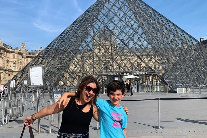 The Louvre Museum & Pyramid with happy clients on a wonderful afternoon in central Paris.