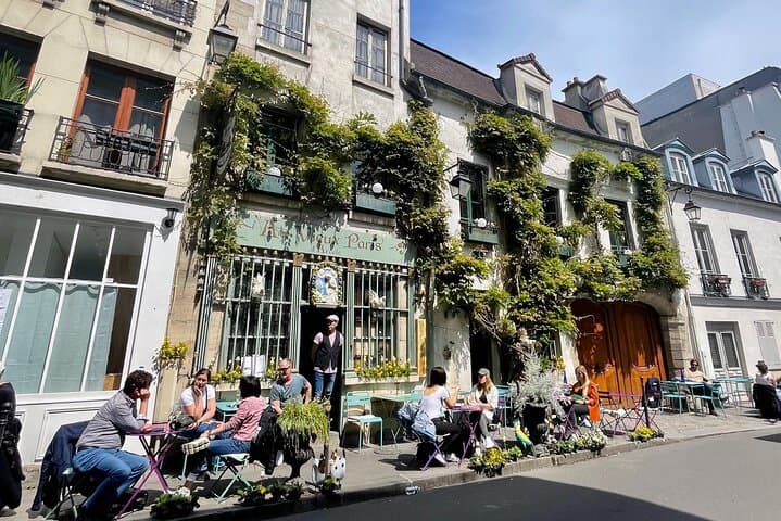 people sat at a tables outside of a café