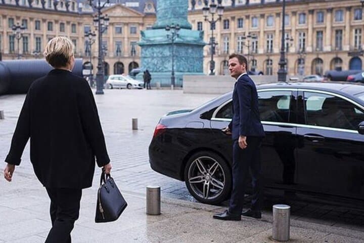Professional driver waiting at DE meeting point for an exclusive transfer.