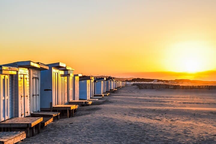 Calais Beach: The iconic white chalets lined up on the sand at sunset.