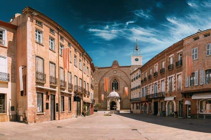 Place de la Loge: The historic heart paved with pink marble, surrounded by the City Inn and the Palais de la Députation.