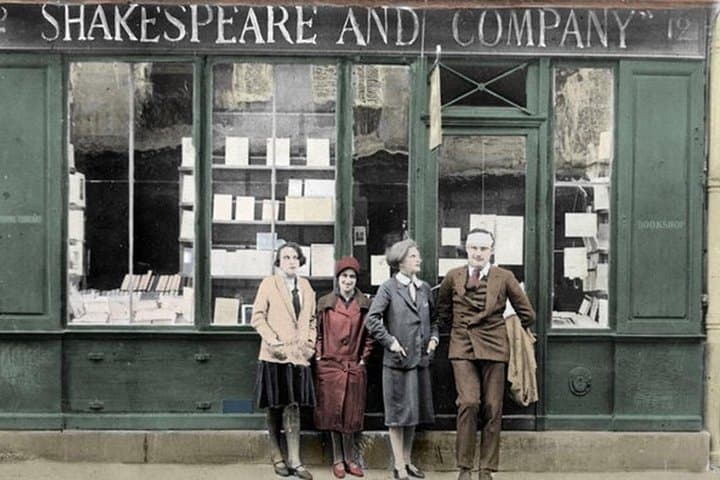 Hemingway posing with Sylvia Beach & friends in front of the original bookstore Shakespeare & Company