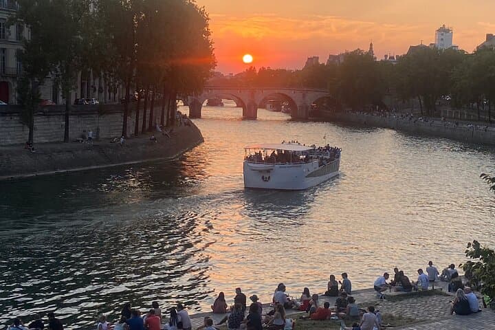 Sunset on the Seine river, a favorite Parisian summer spot to stroll, listen, and savor the flavors of Paris.