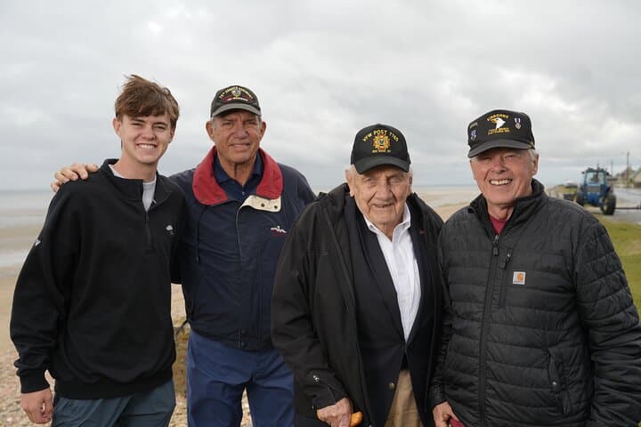World War II and Vietnam veterans walk the beaches of Normandy.